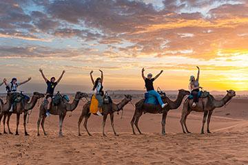 沙漠中骑骆驼的学生